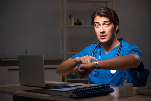 Young handsome doctor working night shift in hospital   