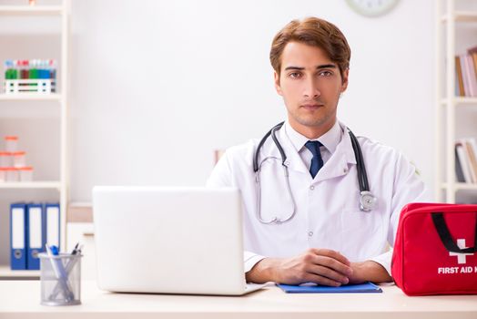 Young doctor with first aid kit in hospital