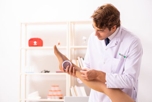 Male doctor checking joint flexibility with goniometer  