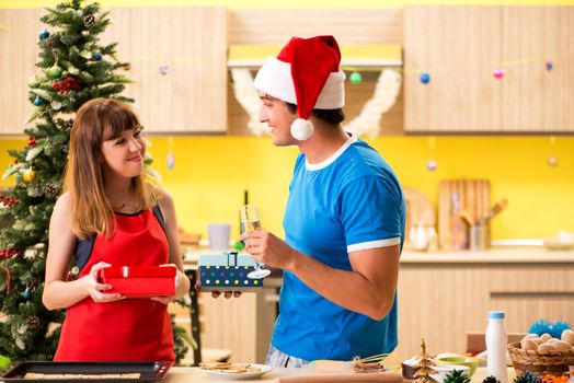 Young couple celebrating Christmas in kitchen 