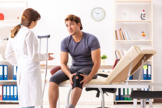 Handsome american footbal player visiting female doctor traumatologist 