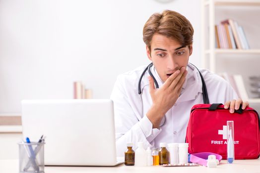 Young doctor with first aid kit in hospital