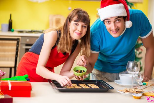 Young couple celebrating Christmas in kitchen 