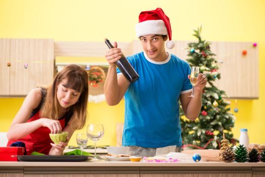 Young couple celebrating Christmas in kitchen 