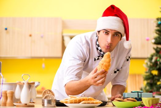 Young chef husband working in kitchen at Christmas eve 