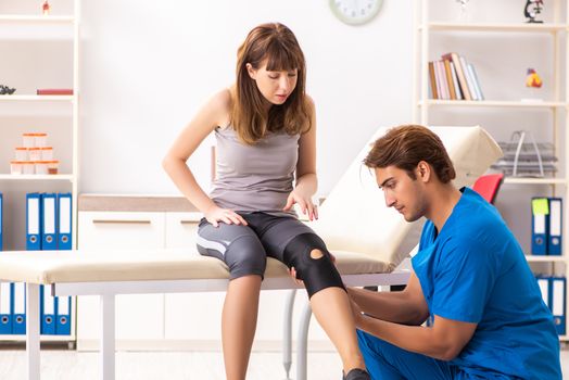 Young female patient visiting male doctor traumatologist 