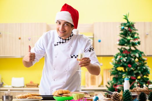 Young chef husband working in kitchen at Christmas eve 