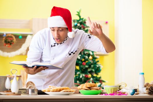 Young chef husband working in kitchen at Christmas eve 