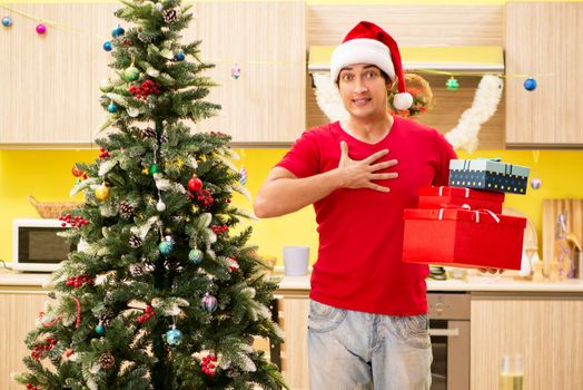 Young man celebrating Christmas in kitchen 