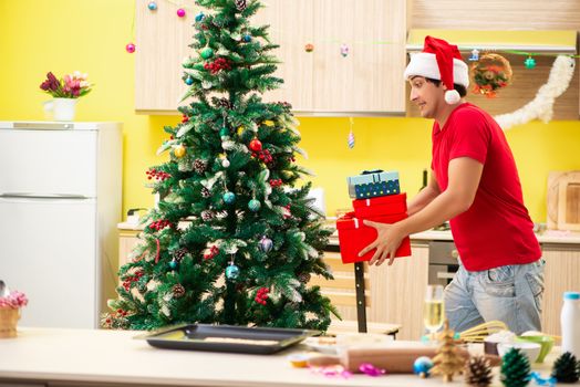 Young man celebrating Christmas in kitchen 
