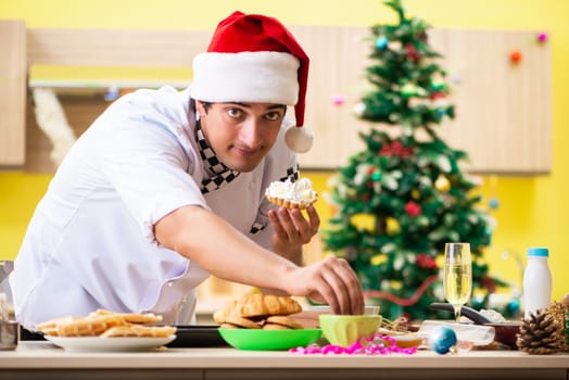 Young chef husband working in kitchen at Christmas eve 