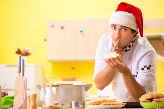 Young chef husband working in kitchen at Christmas eve 