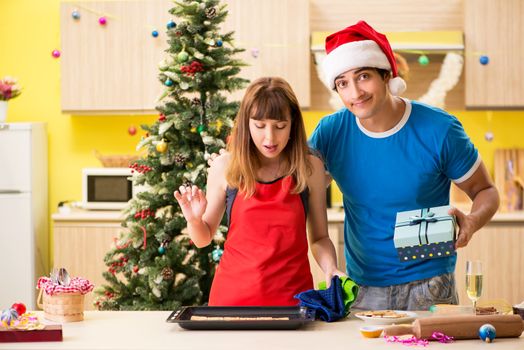 Young couple celebrating Christmas in kitchen 