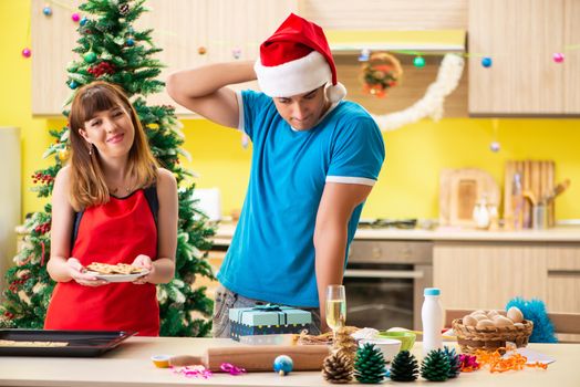 Young couple celebrating Christmas in kitchen 