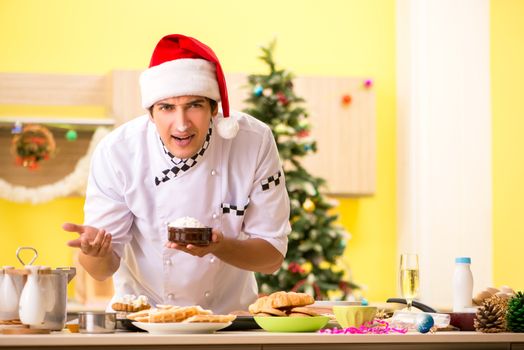 Young chef husband working in kitchen at Christmas eve 