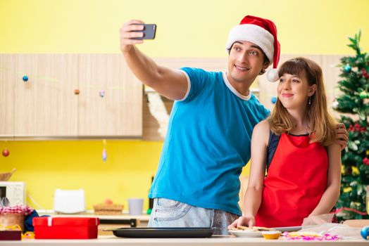 Young couple celebrating Christmas in kitchen 