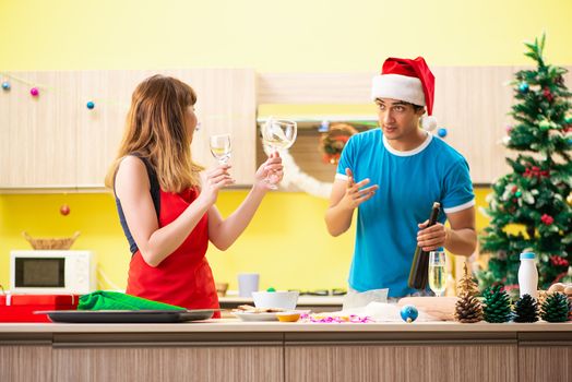Young couple celebrating Christmas in kitchen 