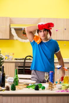 Young man cleaning kitchen after Christmas party 