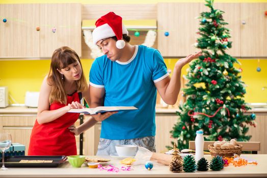 Young couple celebrating Christmas in kitchen 