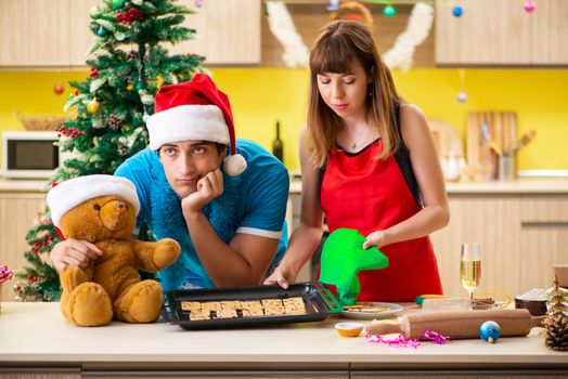 Young couple celebrating Christmas in kitchen 