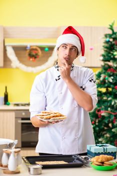 Young chef husband working in kitchen at Christmas eve 