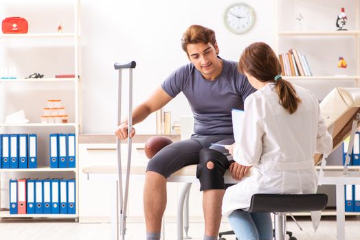 Handsome american footbal player visiting female doctor traumatologist 