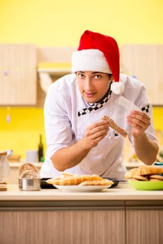 Young chef husband working in kitchen at Christmas eve 