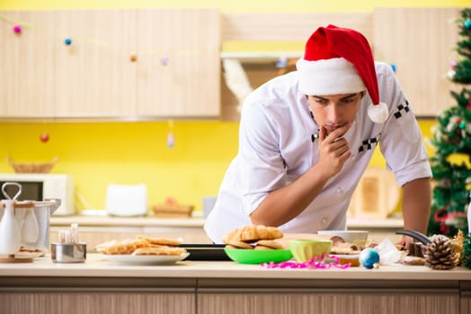 Young chef husband working in kitchen at Christmas eve 