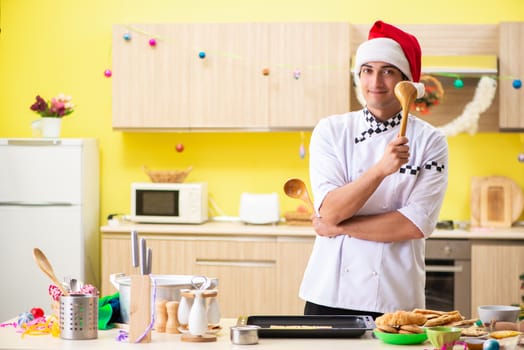 Young chef husband working in kitchen at Christmas eve 
