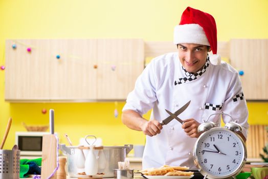 Young chef husband working in kitchen at Christmas eve 