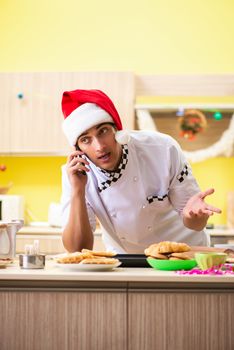 Young chef husband working in kitchen at Christmas eve 