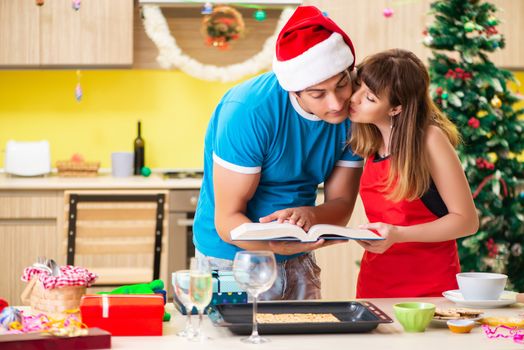 Young couple celebrating Christmas in kitchen 