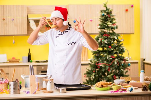 Young chef husband working in kitchen at Christmas eve 