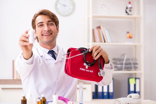 Young doctor with first aid kit in hospital