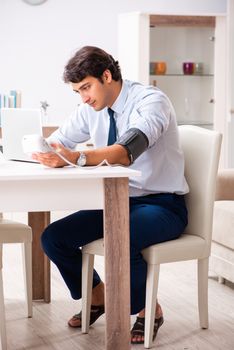 Man under stress measuring his blood pressure