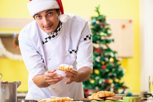 Young chef husband working in kitchen at Christmas eve 
