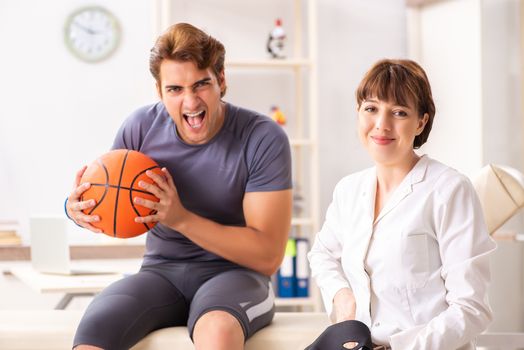 Handsome basketball player visiting female doctor traumatologist   