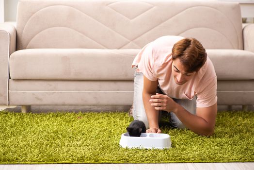 Young man playing with kitten at home