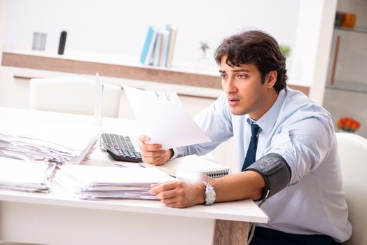 Man under stress measuring his blood pressure