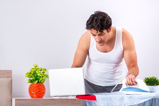 Young man freelancer ironing in the bedroom 