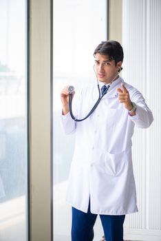 Young handsome doctor standing at the window 