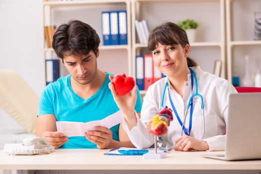 Young man visiting female doctor cardiologist 