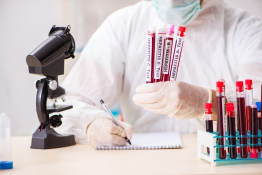 Young handsome lab assistant testing blood samples in hospital 