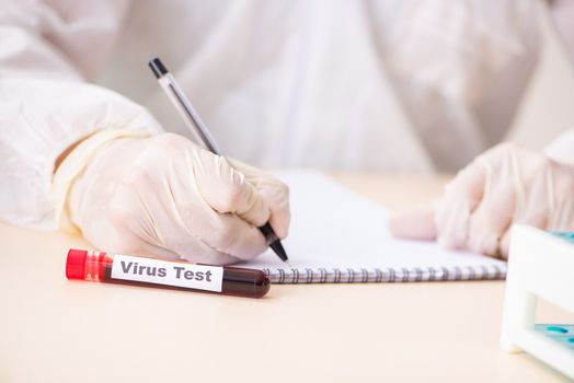 Young handsome lab assistant testing blood samples in hospital 