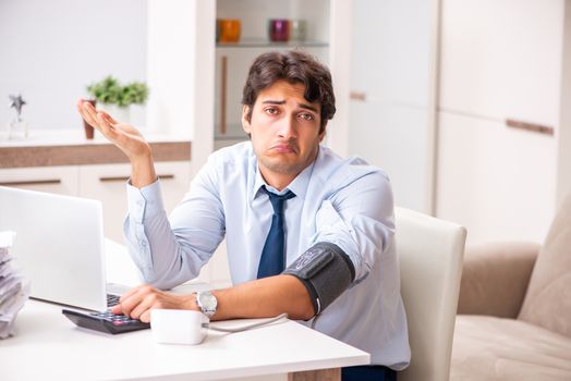 Man under stress measuring his blood pressure