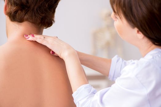 Young female doctor chiropractor massaging male patient