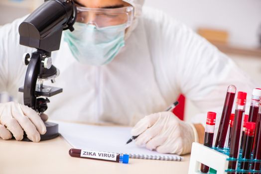 Young handsome lab assistant testing blood samples in hospital 