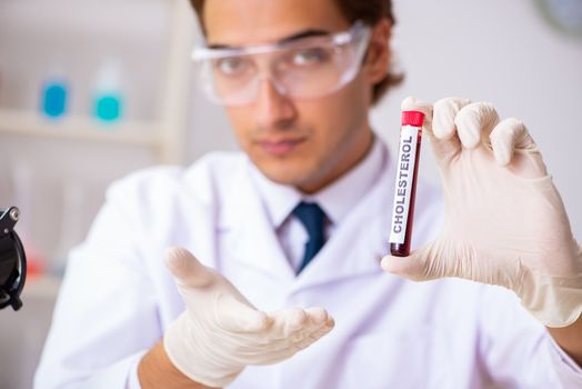 Young handsome lab assistant testing blood samples in hospital 