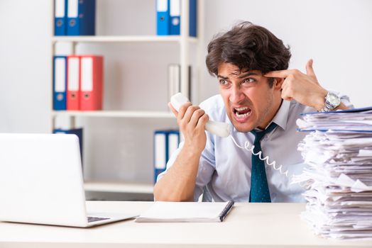 Overloaded busy employee with too much work and paperwork