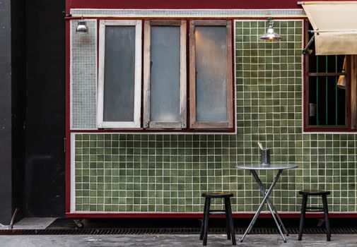 Table and wooden chairs in front of a traditional Chinese food shop. Concept and design front of Chinese retro style. No focus, specifically.